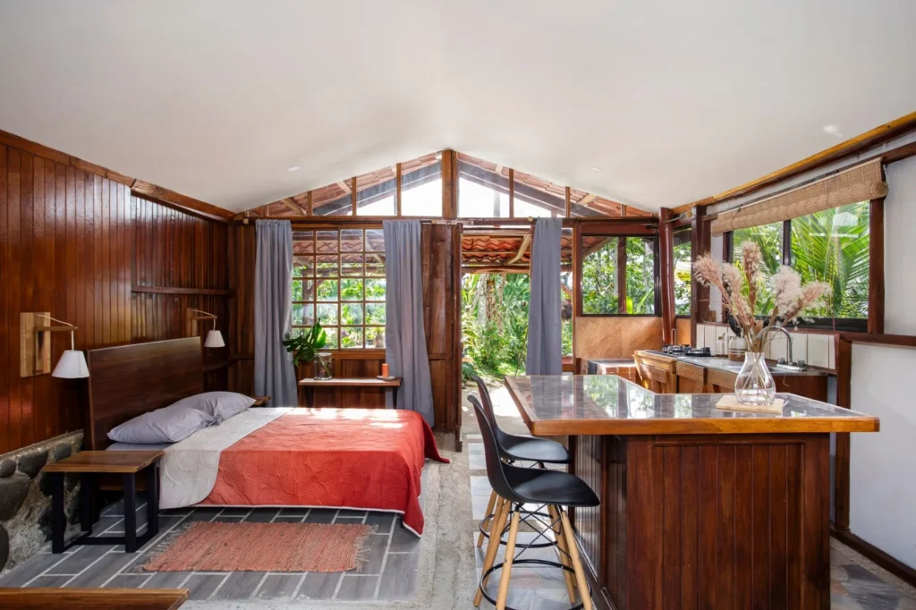 Habitación en Iriká Lodge, Turrialba, Costa Rica con cama y ventanales.