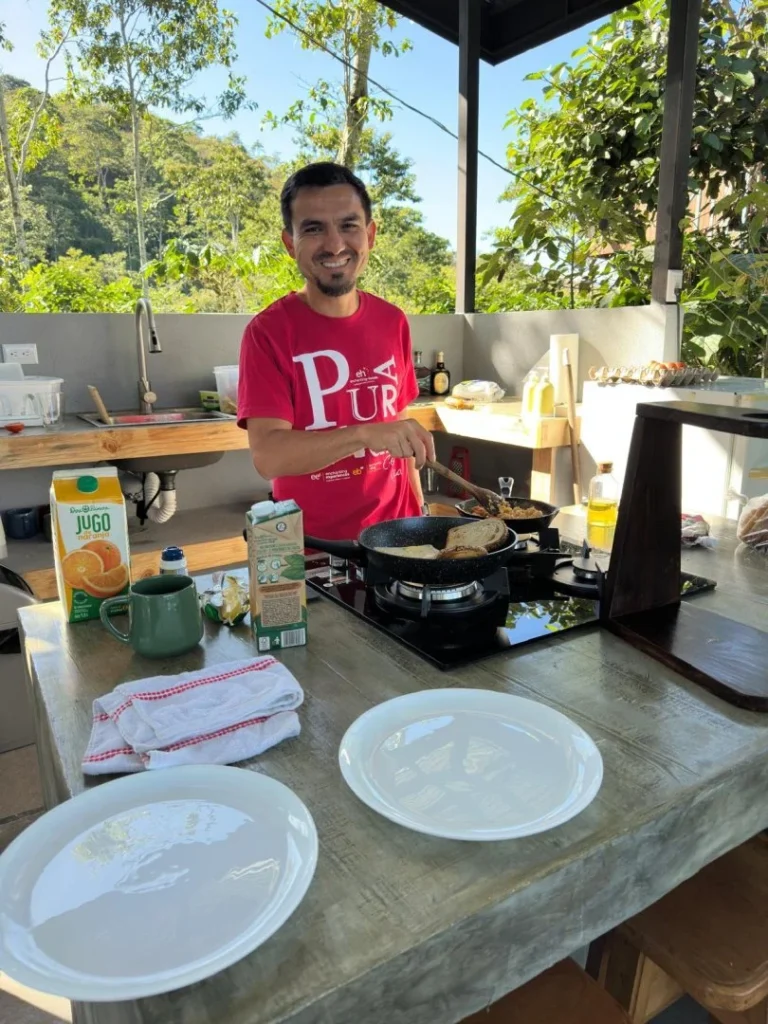 Hombre cocinando al aire libre en Iriká Lodge, Turrialba, Costa Rica.